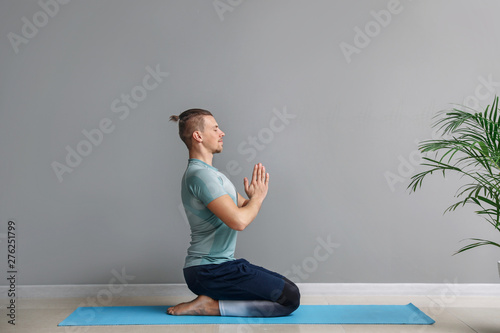Sporty man practicing yoga ...