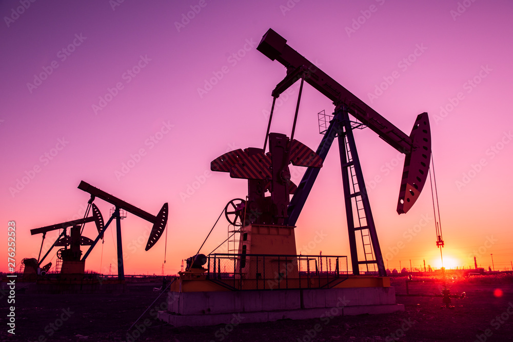 Oil pumps are running in the sunset at the oil field. Oil pumps are running in the sunset at the oil field.