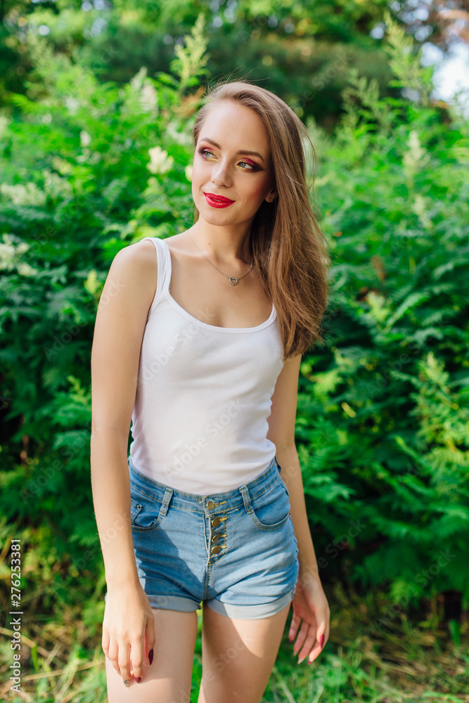 Young woman dressed in white shirt in summer park Young woman dressed in white shirt in summer park