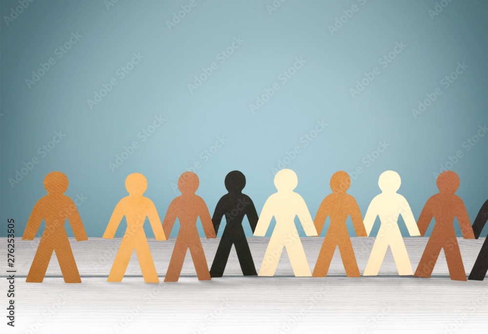 Row of paper people holding hands on table on light background Row of paper people holding hands on table on light background