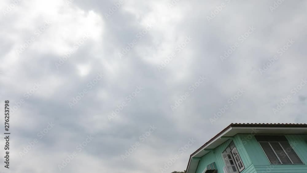 Time lapse (30 second interval) Very fast moving white clouds and blue sky over roof home Time lapse (30 second interval) Very fast moving white clouds and blue sky over roof home