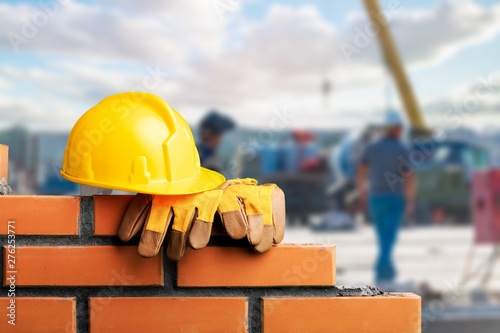 Yellow helmet with equipment on construction background photo