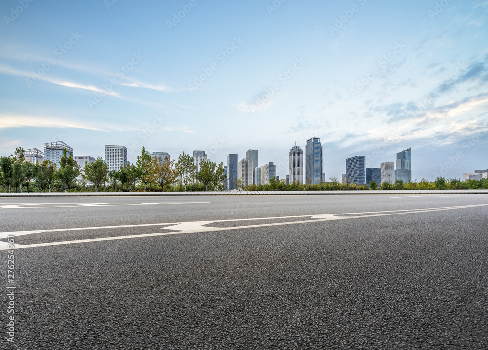 empty asphalt road with city skyline background in china. empty asphalt road with city skyline background in china.