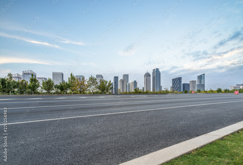 empty asphalt road with city skyline background in china. empty asphalt road with city skyline background in china.