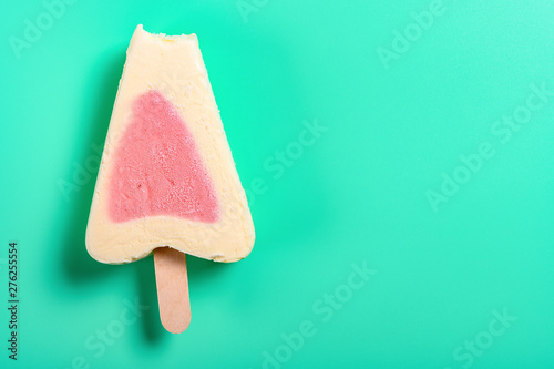 top view fresh strawberry flavor popsicle with a bite on a green background