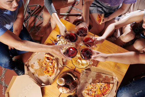 Group of young people toasting with wine glasses at party, view from above