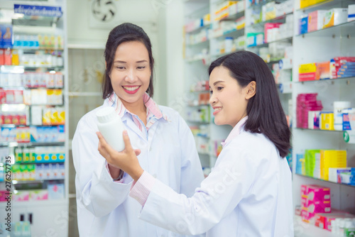 Two asian female pharmacist working in pharmacy (chemist shop or drugstore)