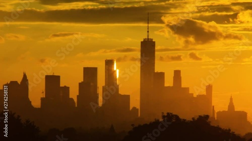 Close up of dowtown NYC, financial district, and World Trade Center as layered clouds pass behind during sunset photo