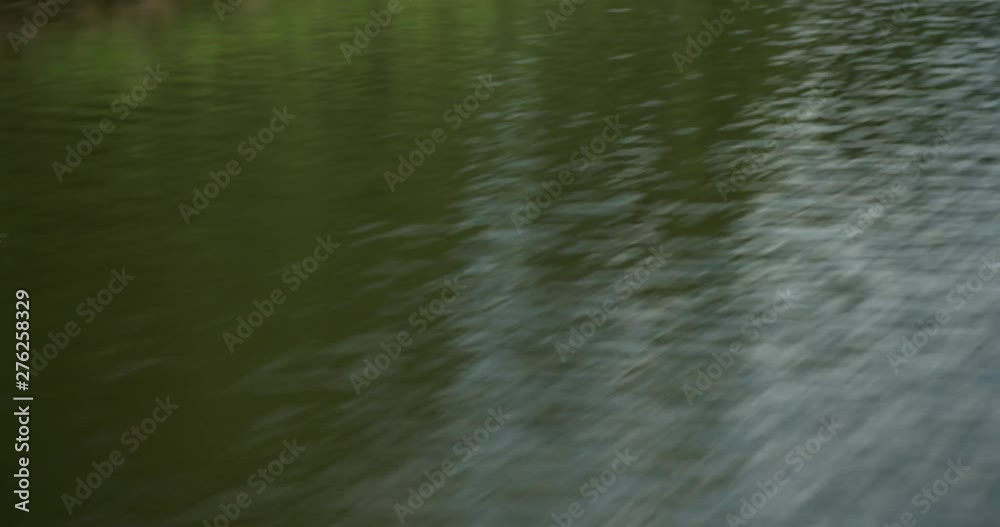 Looking over side of speeding jet boat at water passing by. Shoreline reflecting in water. Looking over side of speeding jet boat at water passing by. Shoreline reflecting in water.