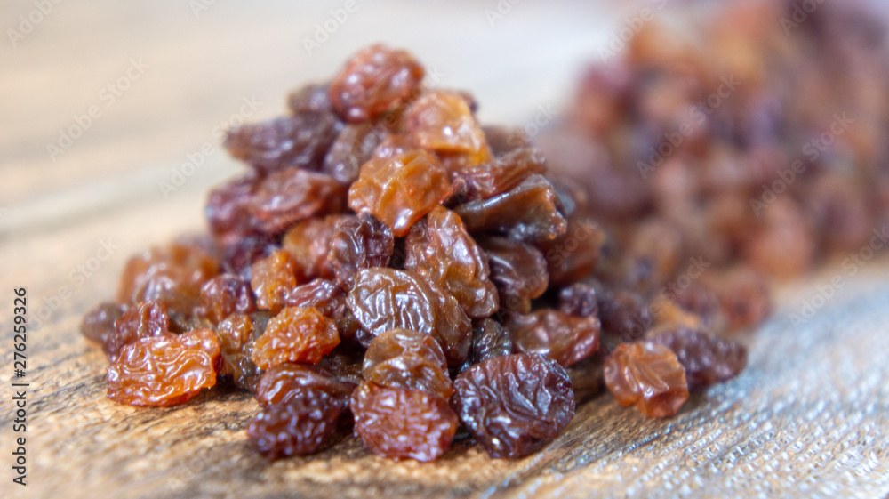Obraz premium Dried raisins or kismis on wooden background.