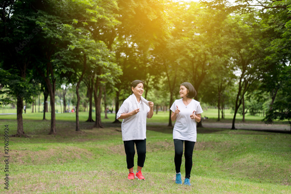 Fototapeta premium Portrait of elderly asian woman with daughter running in the park in early morning together,Healthy and Take care concept