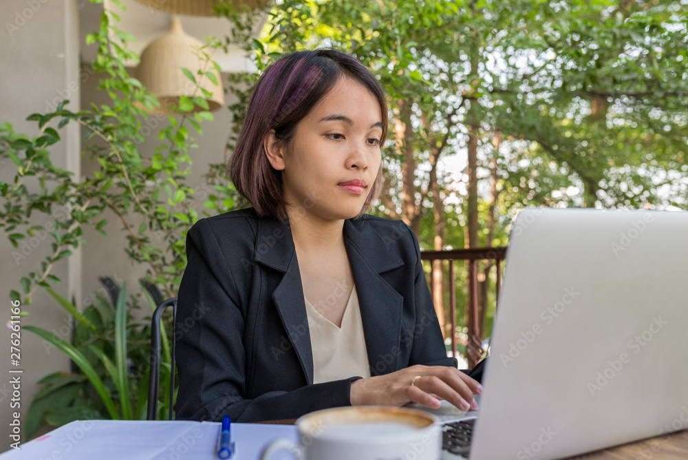 Portrait of hard-working woman working on laptop in garden background Portrait of hard-working woman working on laptop in garden background