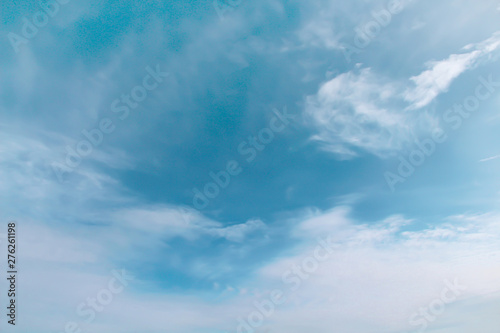 White clouds patterns on bright blue sky background with light wind