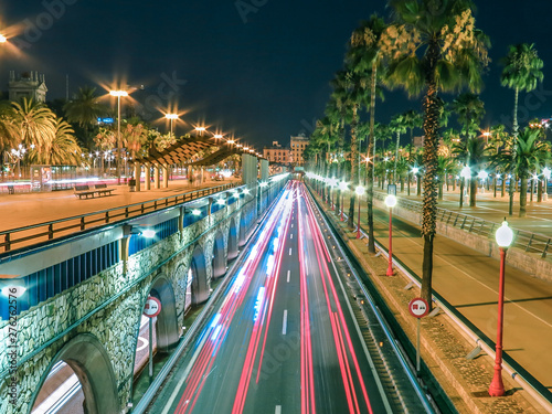 Canvas Print Ronda Litoral motorway in Barcelona, Spain taken from a pedestrian bridge with red streaks from passing cars and palm trees alongside