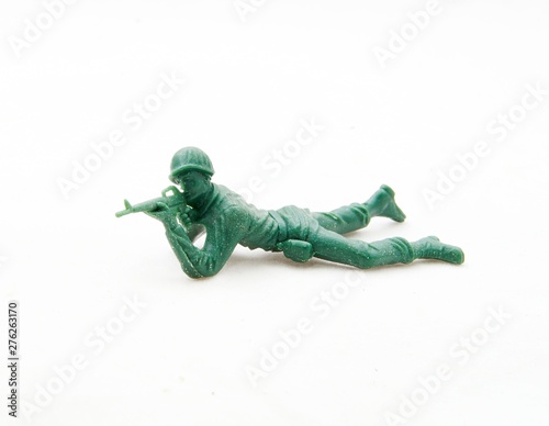 Plastic green toy soldier laying down aiming