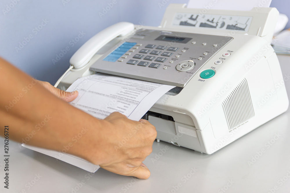 hand man are using a fax machine in the office hand man are using a fax machine in the office