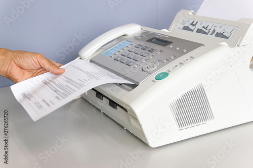 hand man are using a fax machine in the office