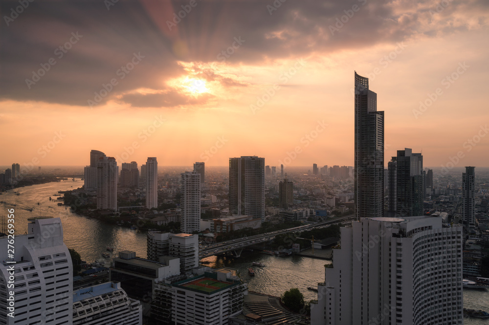 Cityscape of skyscraper with Chao Phraya river at sunset in Bangkok