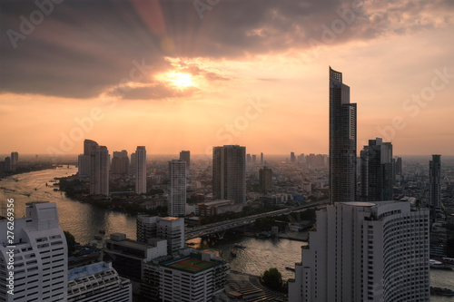 Cityscape of skyscraper with Chao Phraya river at sunset in Bangkok