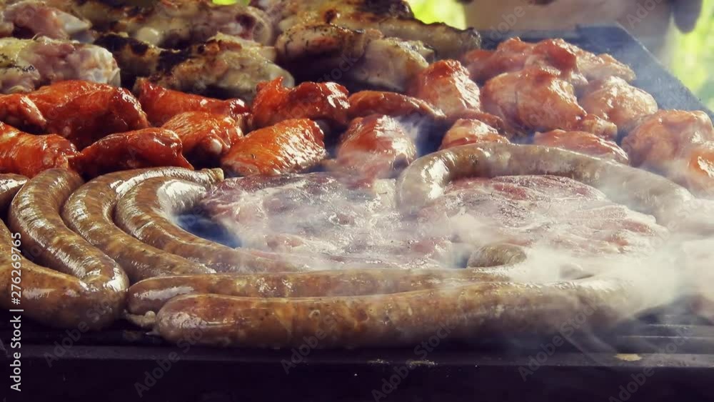 Grilled Sausage On The Flaming Grill. Bearbeque Outdoors with other meat on it, pork, chicken, mititei Grilled Sausage On The Flaming Grill. Bearbeque Outdoors with other meat on it, pork, chicken, mititei