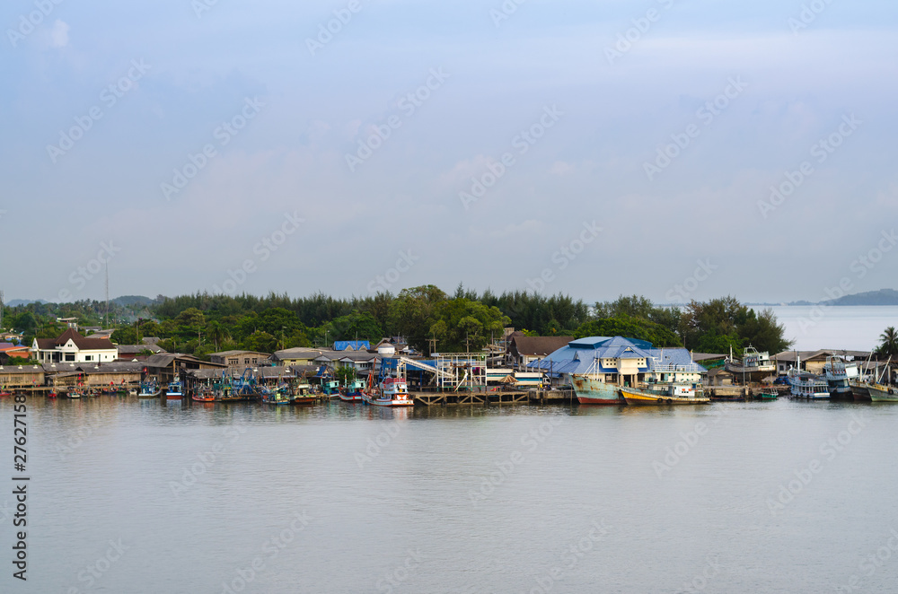 Asian fishing village with boat is docked at the dock.