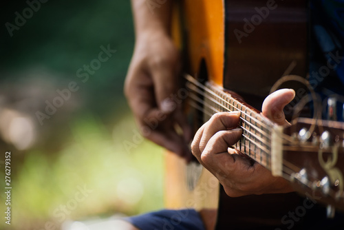 travel, tourism, hike, leisure concept -  Hipster guy classic guitar practice by hand, Happy man playing aoustic guitar at camping,close up,copy space for text. photo