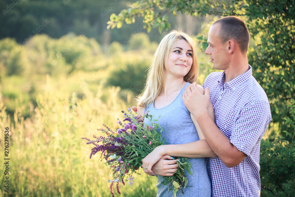 Man and woman on nature with a bouquet of flowers. Couple in love. Man and woman on nature with a bouquet of flowers. Couple in love.
