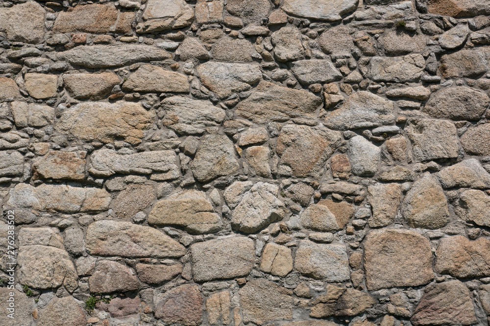 Old, rough, uneven stone wall of historic castle