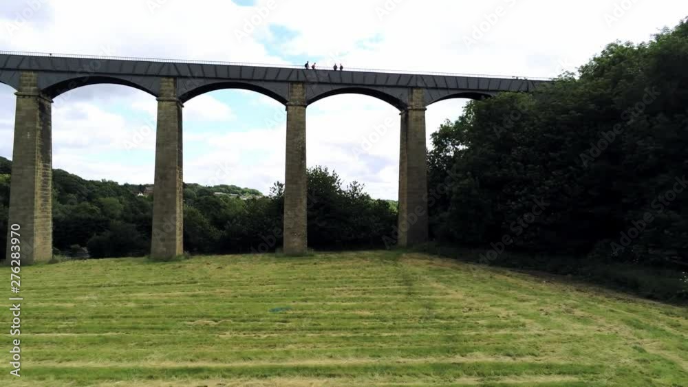 Pontcysyllte Aqueduct arch bridge canal waterway crossing. Pull back low angle over grass field. Pontcysyllte Aqueduct arch bridge canal waterway crossing. Pull back low angle over grass field.
