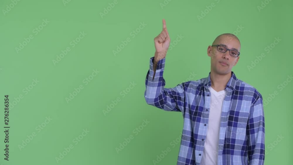 Stressed bald hipster man pointing up Stressed bald hipster man pointing up