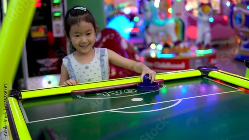 Happy child playing table air hockey at Arcade centre.slow motion