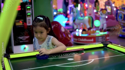 Happy child playing table air hockey at Arcade centre.slow motion