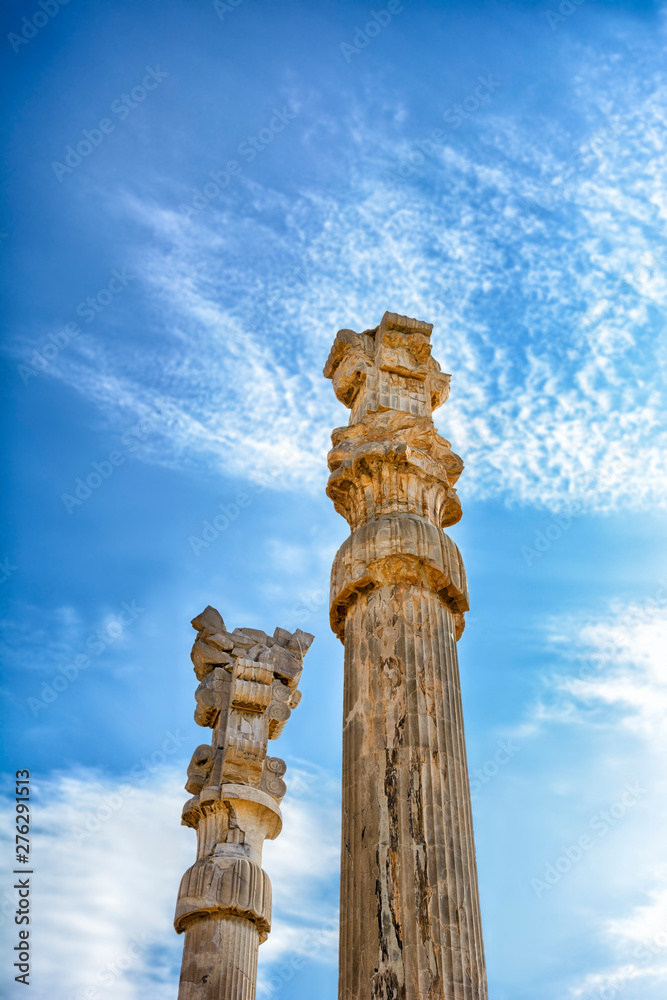 The majestic columns, Persepolis. Iran is the capital of the Achaemenids. The ancient city of the Persians. Bright majestic monuments. Blue sky and clouds background.