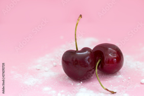 Two cherries isolated on pink background top view, healthy concept modern design powdered sugar