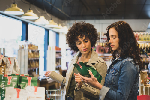 Young adult females food shopping in a grocery store photo
