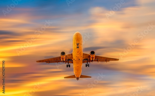 Airplane flying above dramatic clouds during sunset sky © somchairakin