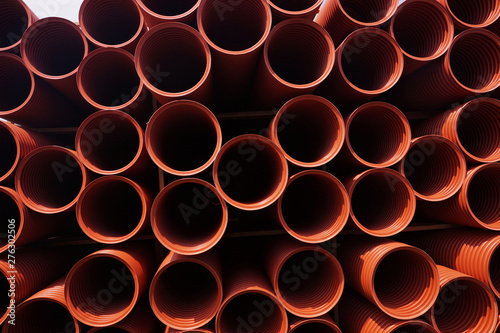 Sewer pipes stacked on shelves. Composition of building materials.