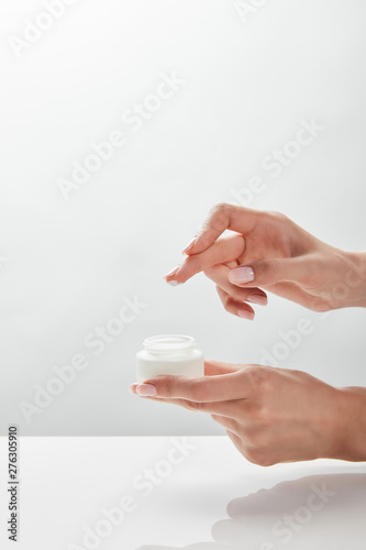 cropped view of woman holding jar with cream in hands © LIGHTFIELD STUDIOS