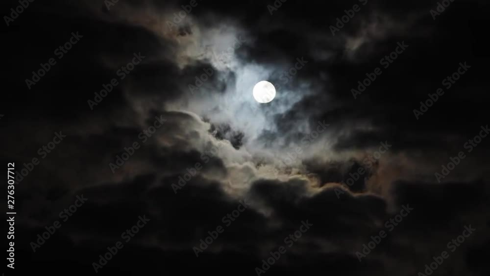 Slow time lapse of stationary full moon with halo behind clouds, copy space Slow time lapse of stationary full moon with halo behind clouds, copy space