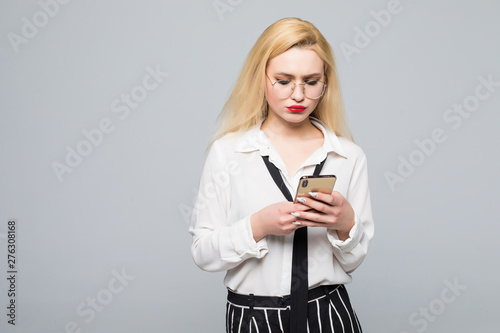 Pleased business woman iwriting message on smartphone over white background