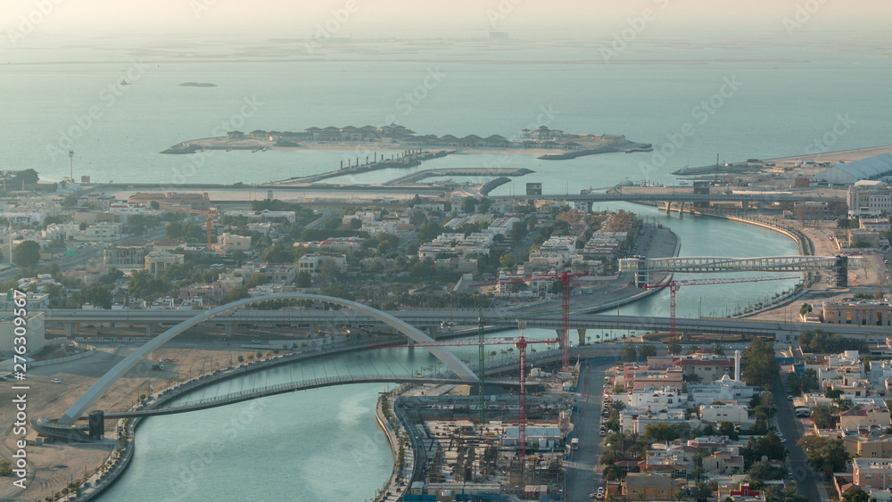 Obraz premium Dubai water canal with footbridge during sunset aerial timelapse from Downtown skyscrapers rooftop