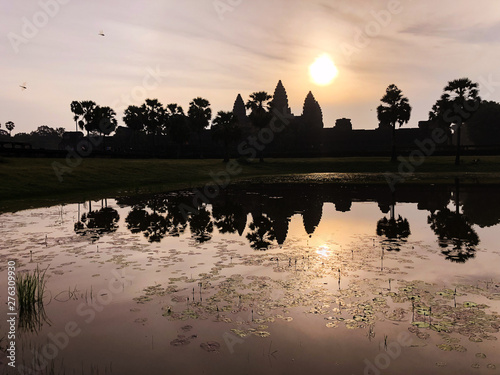silhouette of Angkor Wat temple and its reflections in a pond