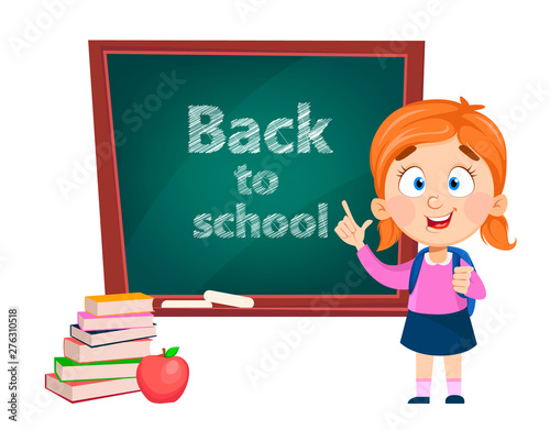 Back to school. Cute girl standing near blackboard