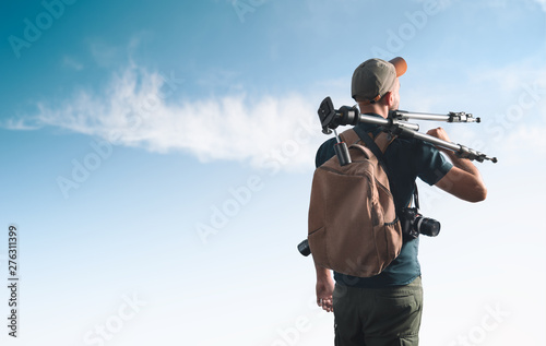 Photographer with photographic equipment. View from the back.