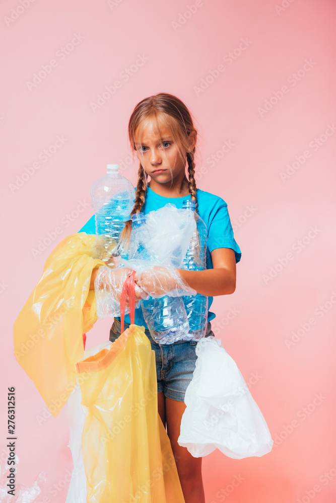 Little girl holding the plastic bags and plastic bottle for recycling Little girl holding the plastic bags and plastic bottle for recycling
