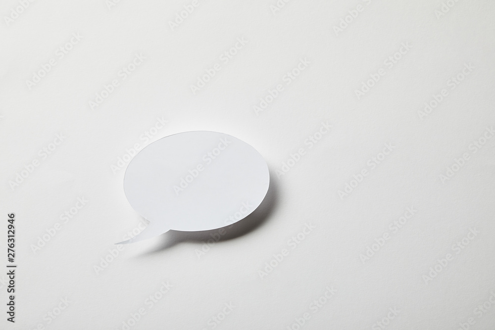 small paper speech bubble on white surface small paper speech bubble on white surface