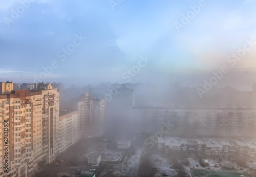 Fog like a cloud covering part of the houses in the city.