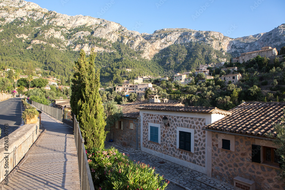 Obraz premium Beautiful view of old mountain village Deia in Mallorca on a sunny day. Deia traditional stone village in Majorca Tramuntana mountain