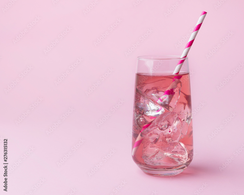Pink rose cocktail on a pink background with striped pink straw. Pink rose cocktail on a pink background with striped pink straw.