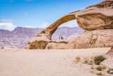 Natural arch in desert with sandstone and granite rock Wadi Rum in Jordan